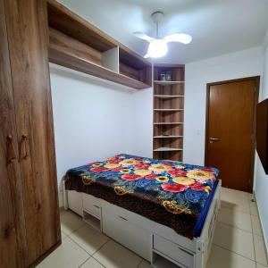 a bedroom with a bed with a colorful blanket on it at Requinte e sofisticação in Praia Grande