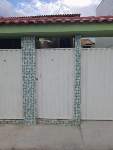 eine Reihe weißer Tore auf einem Haus in der Unterkunft Cantinho da Bethânia in São Pedro da Aldeia