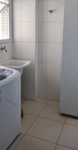 a white bathroom with a sink and a shower at Requinte e sofisticação in Praia Grande