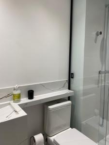 a bathroom with a toilet and a glass shower at Loft em prédio com piscina próximo da Oktoberfest Blumenau in Blumenau +15 photos