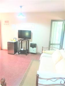 a living room with a white couch and a television at COMODA SUITE EN UNA UBICACIÓN PRIVILEGIADA DE LA CIUDAD DE MENDOZA in Mendoza