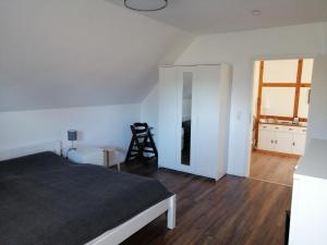 Schlafzimmer mit einem Bett und Holzboden in der Unterkunft In Summo Monte in Ottersberg