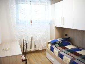 une petite chambre avec un lit et une fenêtre dans l'établissement Alpine Escape with Charm, à Sestrières