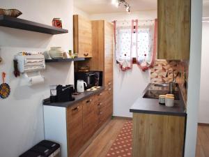 een kleine keuken met houten kasten en een wastafel bij Nice apartment in Sestriere with ski storage in Sestriere