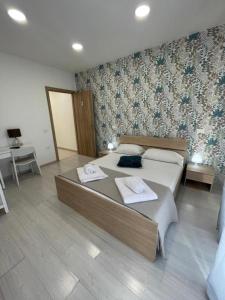 een slaapkamer met een groot bed en 2 handdoeken bij Central Rooms 128 in Palermo