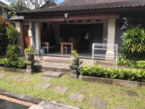 a house with a porch with a bench and a table at Bali Breeze Bungalows in Ubud