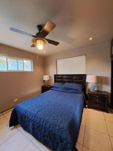 a bedroom with a blue bed and a ceiling fan at Departamentos Orange in Ensenada