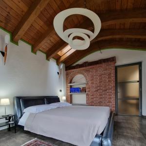 a bedroom with a large bed and a brick wall at Maison Bodroz appartamento Charme in Aosta