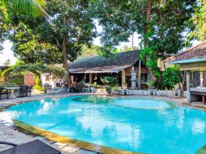 a swimming pool in front of a house at Deutsches-Eck Rikesti in Lovina