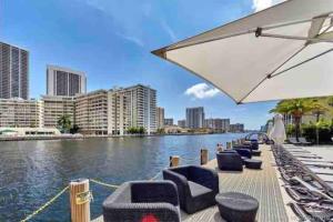 a row of chairs and an umbrella next to a river at Modern apartment in luxury condominium AB- 2 bed/2 ba in Hallandale Beach