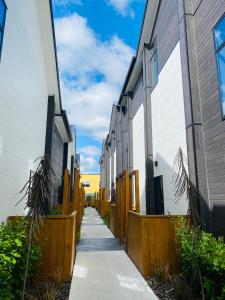 a sidewalk between two buildings with a fence at Home sweet home Christchurch Centre in Christchurch