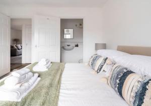 a white bedroom with two beds and a rug at Peniel Properties - Welwyn Garden City in Welwyn Garden City