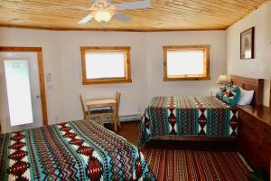 1 dormitorio con 2 camas y ventilador de techo en Red Moon Lodge en Moab