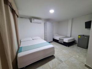 1 dormitorio con 2 camas y TV. en Posada Turística Miss Geidy, en San Andrés