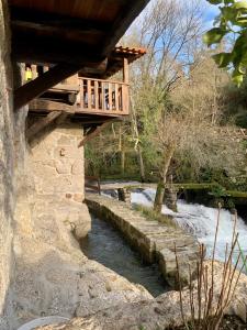 a wooden bridge over a river with a river at Quinta das Bollótâs in Travassós