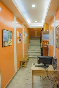 a hallway with orange walls and a staircase at Zeus Hostel in Athens