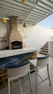 uma cozinha com 2 cadeiras e um forno de pizza em Apartamento-Cobertura de Luxo Vista Mar em Salvador em Salvador