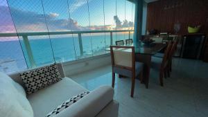 Apartamento-Cobertura de Luxo Vista Mar em Salvador في سلفادور: غرفة معيشة مع أريكة وطاولة مطلة على المحيط
