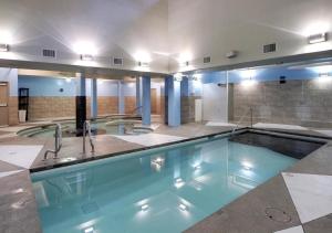 a large swimming pool in a building at LUXE Penthouse with Mountain Views Solar A Resort & Spa in Canmore