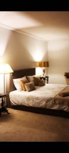 - une chambre avec un lit avec deux lampes et deux tables dans l'établissement Casa do Monte, à Vizela