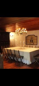 un comedor con una mesa con sillas y una lámpara de araña en Casa do Monte, en Vizela