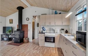 una cucina con mobili bianchi e un forno a piano cottura di 3 Bedroom Beautiful Home In Højslev a Højslev