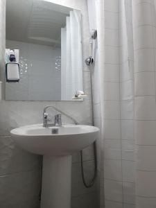 La salle de bains blanche est pourvue d'un lavabo et d'un miroir. dans l'établissement AREX Hongik univ Unit 201, à Séoul