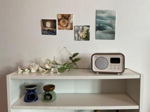 a shelf with a clock and pictures on a wall at AREX Hongik univ Unit 201 in Seoul