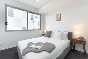 a bedroom with a large bed with two shoes on it at Cozy 2BR w Free Parking Near Westfield Parramatta in Sydney
