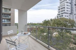 a balcony with a table and chairs and a view at Cozy 2BR w Free Parking Near Westfield Parramatta in Sydney