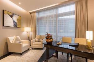 a living room with a desk and chairs and a window at Opus Bukit Bintang in Kuala Lumpur