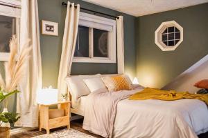 a bedroom with a bed and two windows at Lakefront getaway *cozy & peaceful *dock & swings 