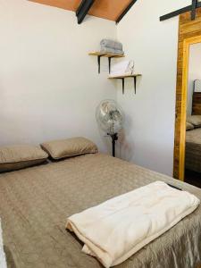 Schlafzimmer mit einem großen Bett und einem Ventilator in der Unterkunft Cabañas del Bosque in Nandayure
