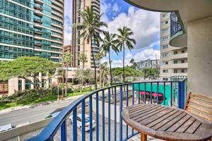 einen Balkon mit einem Holztisch und Straßenblick in der Unterkunft Royal Aloha Wakiki Sweet Home in Honolulu