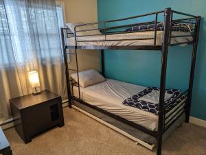 a bedroom with two bunk beds and a night stand at LAKE GEORGE FAMILY VACATION HOME in Lake George