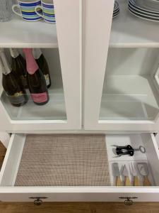 un frigorifero bianco pieno di bottiglie di vino di Recanto Terraneo-Gramado a Gramado