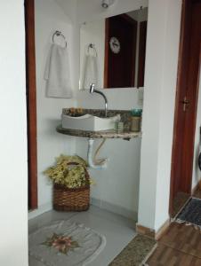 uma casa de banho com um lavatório e um espelho em Casa temporada Cocal/Praia de Itaparica-Vila Velha em Vila Velha