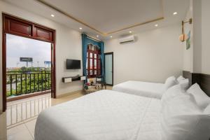 a hotel room with two beds and a window at Hanoi Airport Suites in Sóc Sơn