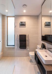 ein Badezimmer mit einer weißen Toilette und einem Waschbecken in der Unterkunft The Rata Luxury Penthouse in Queenstown + 20 Fotos