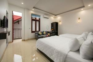 sypialnia z dużym białym łóżkiem i kanapą w obiekcie Hanoi Airport Suites w mieście Sóc Sơn