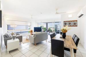 a living room with a table and chairs and a couch at Captain's Lookout - Penthouse Living at Cullen Bay in Larrakeyah
