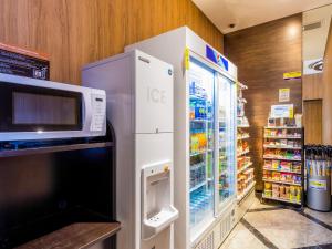 einen Kühlschrank in einem Geschäft mit Mikrowelle in der Unterkunft APA Hotel Asakusa Kuramae Kita in Tokio