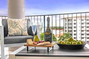 a bottle of wine and a bowl of food on a table at Captain's Lookout - Penthouse Living at Cullen Bay in Darwin
