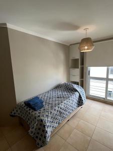 a bedroom with a bed in the corner of a room at Departamento Alta Córdoba in Cordoba