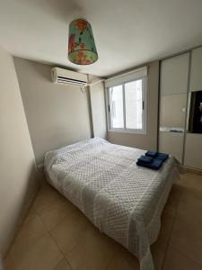 a bedroom with a bed in a room with a window at Departamento Alta Córdoba in Cordoba