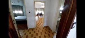 a hallway leading to a room with a bed and a table at Residencia Morón in Morón