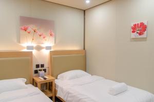 two beds in a room with white sheets at Moriyama Hotel in Mandaue City