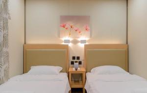 a room with two beds and a painting on the wall at Moriyama Hotel in Mandaue City