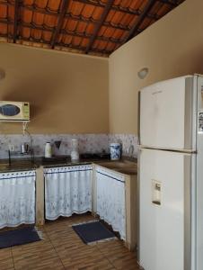 eine Küche mit einem weißen Kühlschrank im Zimmer in der Unterkunft Casa temporada Cocal/Praia de Itaparica-Vila Velha in Vila Velha
