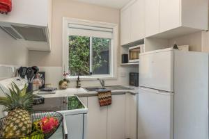 een keuken met een witte koelkast en een raam bij North Hobart cottage in Hobart